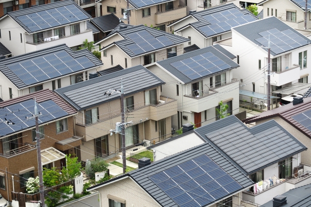 住宅街の屋根に設置された多数の太陽光発電パネル