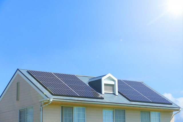 住宅の屋根に設置された太陽光パネルと青空
