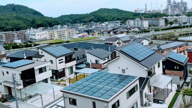 住宅街の屋根に並ぶ太陽光パネルの風景
