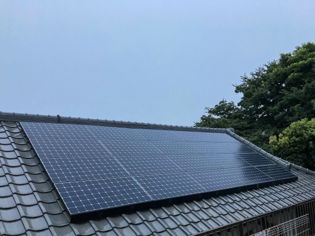 瓦屋根に設置された黒いソーラーパネル