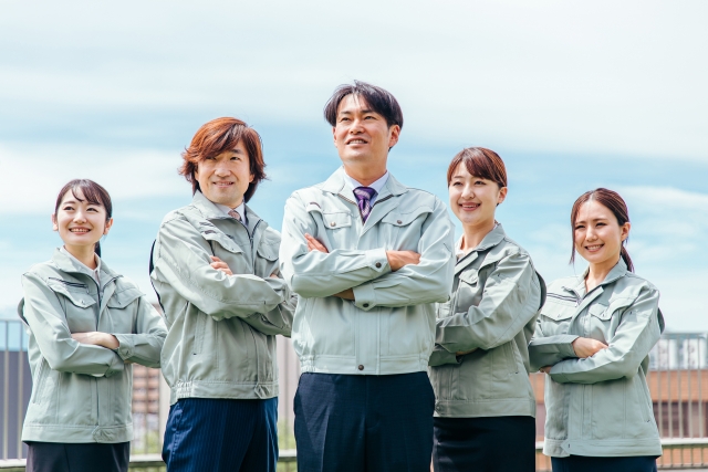 作業着をきた笑顔の会社員(5人・腕組み)